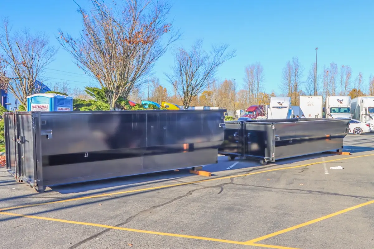 Professional dumpster rental service with roll-off container on residential driveway in Acton